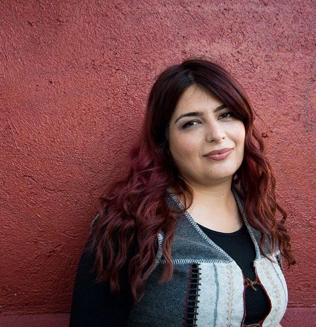 Portrait of Rokhsareh Ghaemmaghami against a red wall